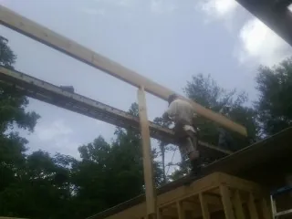 Carpenter setting a ridge beam over a new addition frame — Ice Dam Removal by Roofing Brothers in Waxahachie