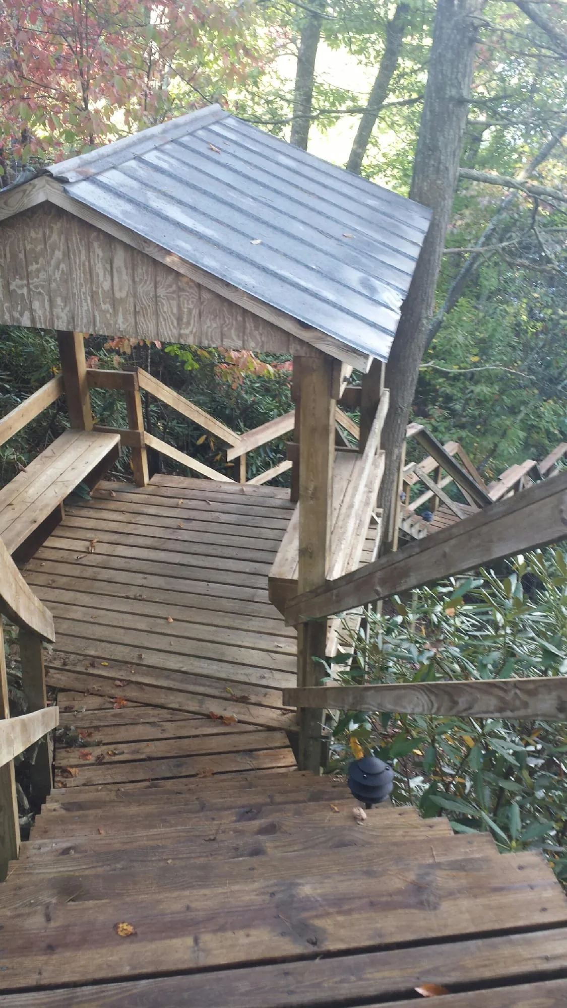 Metal roofed shelter over wooden steps on a wooded walkway — Skylight Repair & Installation work by our crew in Waxahachie