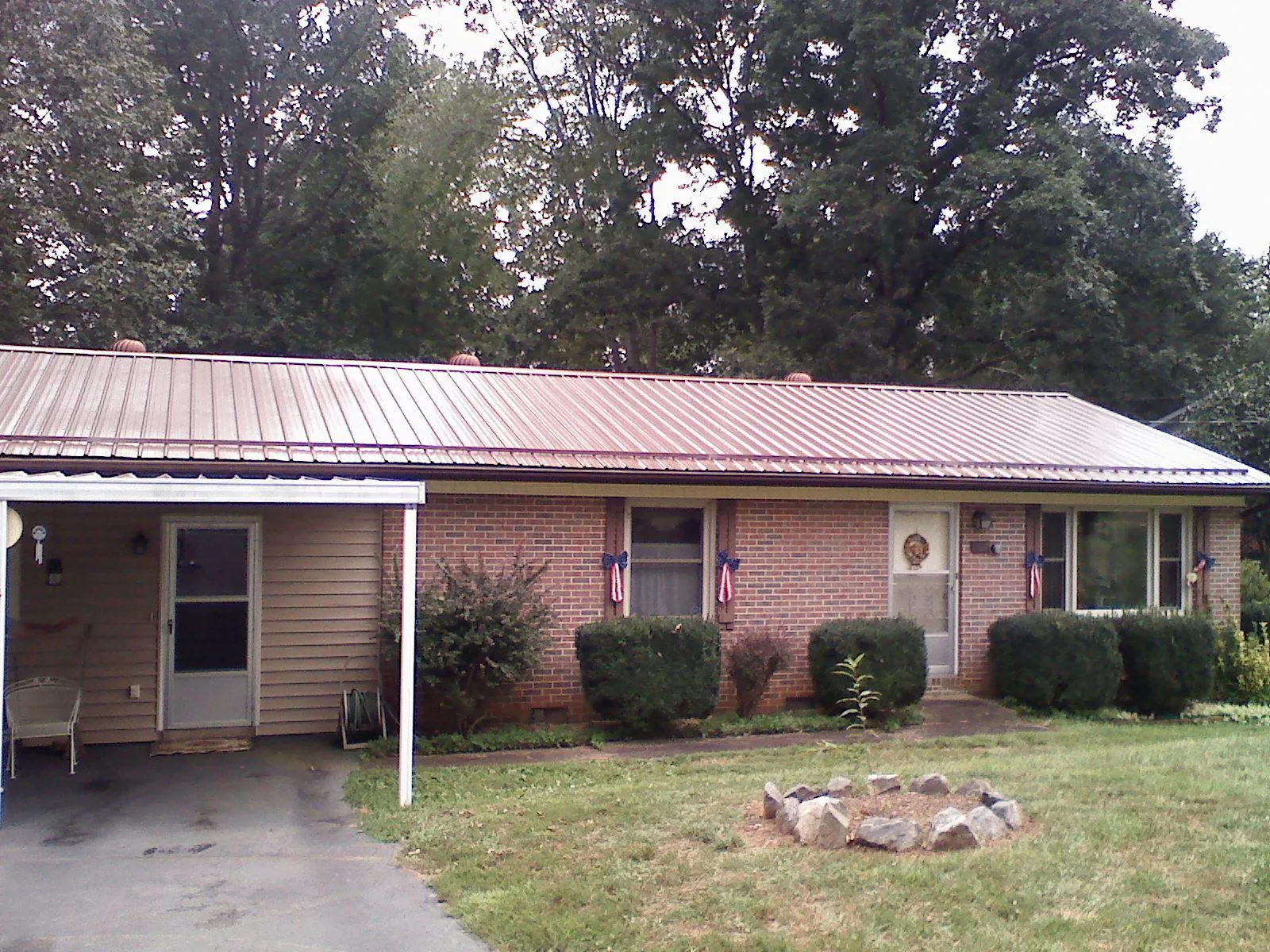 Bronze metal roof and carport on a brick ranch home — Roof Repair work by our crew in Waxahachie