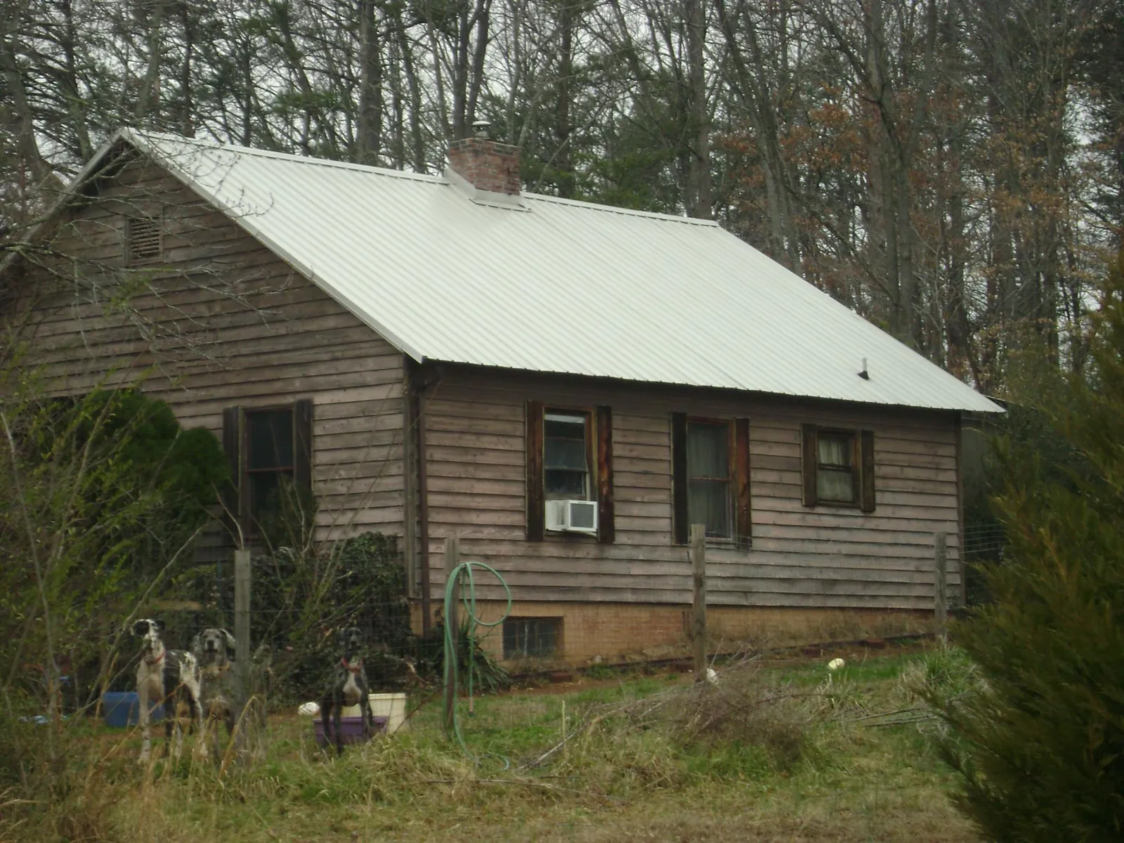White metal roof on an old wood sided farmhouse, from a Asphalt Shingle Roof Repair job in Waxahachie